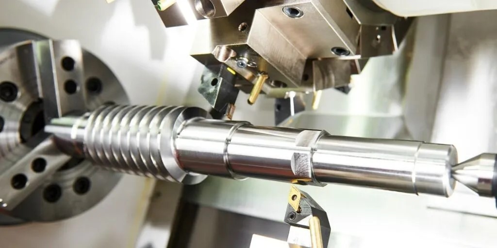 Torno CNC usinando peça cilíndrica metálica